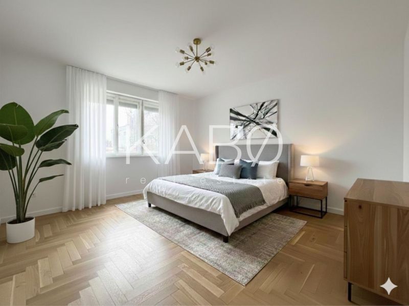 Helles Schlafzimmer in einem Einfamilienhaus mit Holzboden und Zimmerpflanze.