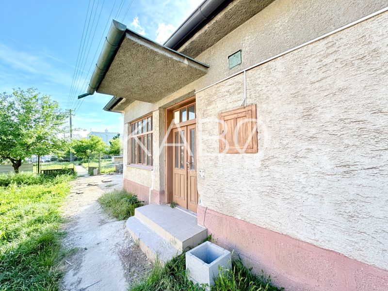 Ein Einfamilienhaus in Šoporňa mit einem Außeneingang und einem grünen Vorgarten.