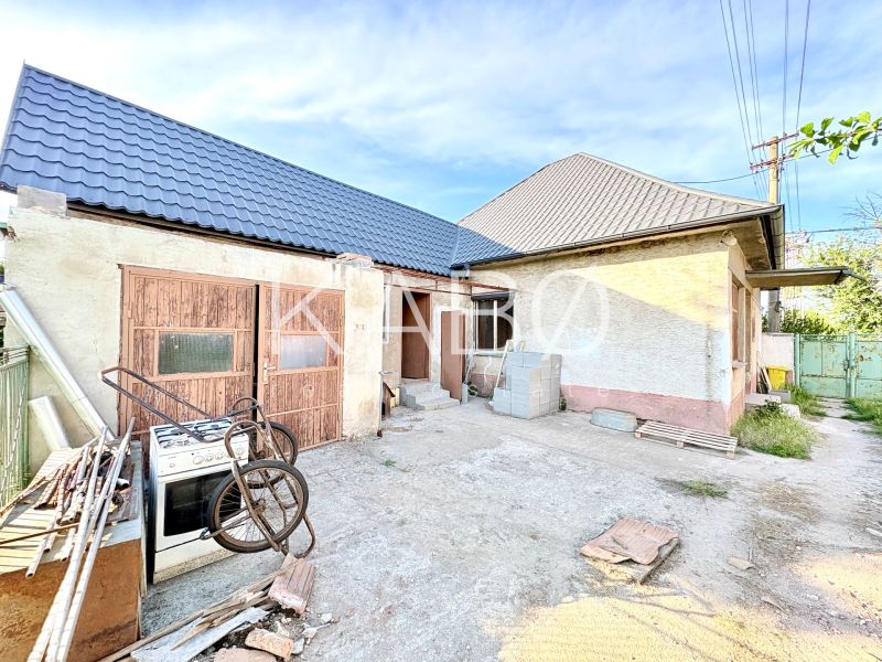 Ein Einfamilienhaus in Šoporňa mit zwei Dächern und einem ungepflegten Hof.