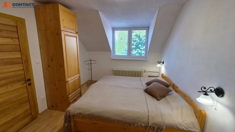 Schlafzimmer in einer 2-Zimmer-Wohnung mit Holzmöbeln und einem Boden mit Holzdekor.