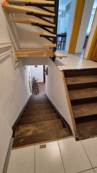 Eine Treppe in einer 2-Zimmer-Wohnung mit Holzdekor und einem Fahrrad am Eingang.