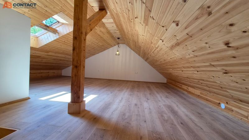 Dachbodenraum mit Holzverkleidung und Boden mit Holzdekor in einer 2-Zimmer-Wohnung.
