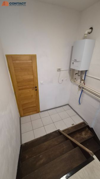 Eine Treppe mit Holzstufen und einem Gaskessel in einer 2-Zimmer-Wohnung.