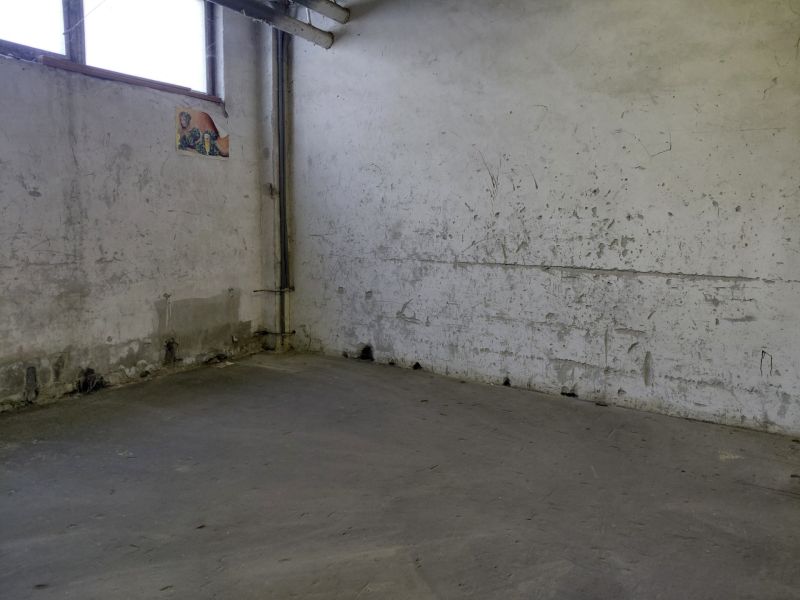 Industrielles Interieur mit abgenutzten Wänden und grauem Boden, Lager und Hallen.