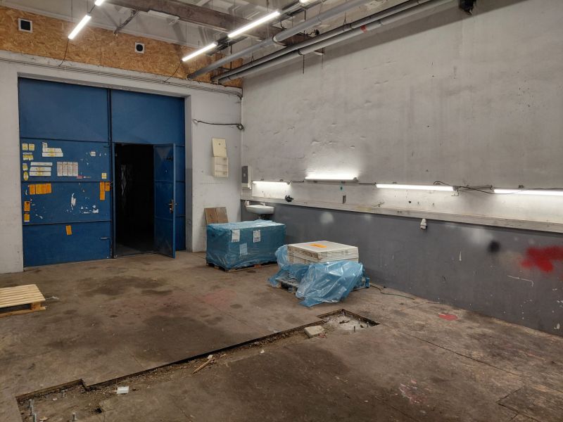 Lagerhallen und -gebäude mit blauen Türen, Beleuchtung und Materialien auf dem Boden mit Holzdekor.