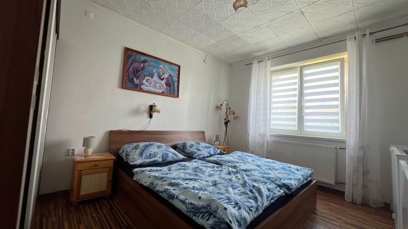 Schlafzimmer in einer 3-Zimmer-Wohnung mit Bett und Bild an der Wand.