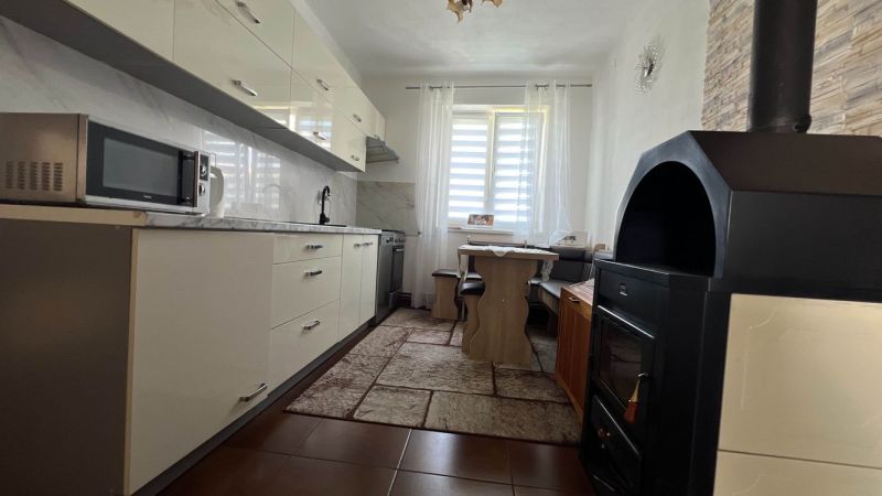 Küche in einer 3-Zimmer-Wohnung mit weißer Küchenzeile und Mikrowelle.