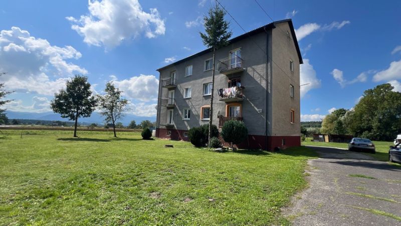 Ein Wohnhaus in Pribylina, umgeben von Grünflächen und blauem Himmel, mit Blick auf die umliegende Landschaft.