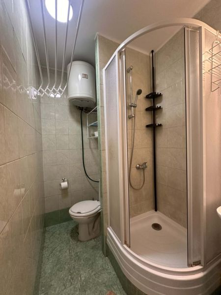 Badezimmer mit Toilette und Dusche in einer Ferienwohnung.