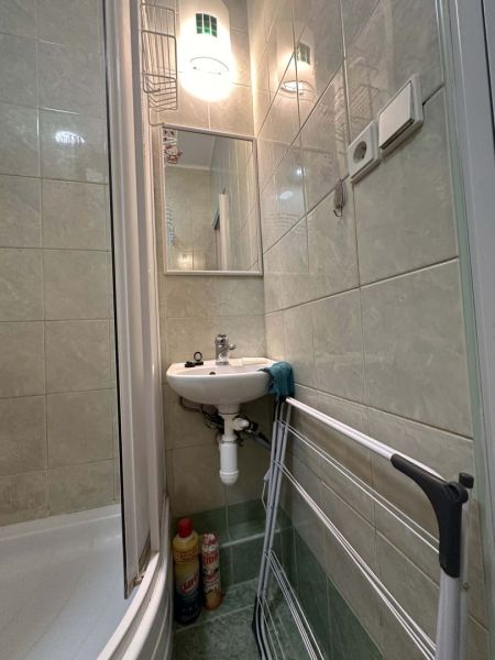 Badezimmer der Ferienwohnung mit Waschbecken, Dusche und Wäscheständer.