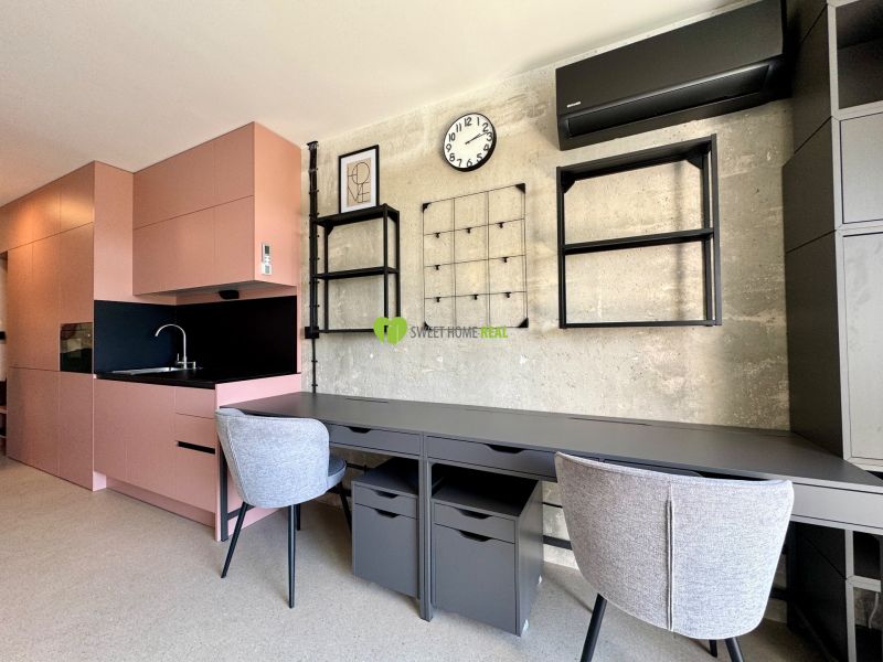 Einzimmerwohnung mit rosa Küche und Schreibtisch, Boden mit Holzdekor.