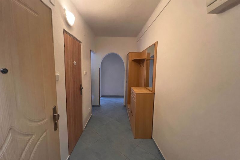 Flur mit Fliesen, Einbaumöbel und ein Bogenübergang in einer 2-Zimmer-Wohnung.
