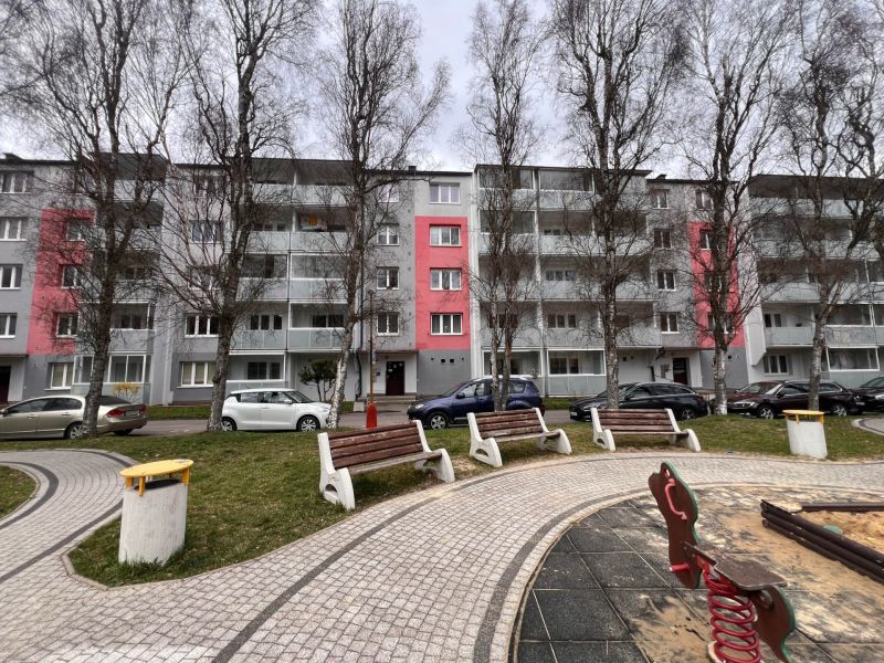 Ein Wohnhaus in Ružomberok mit Bäumen und Parkplätzen vor den Zweizimmerwohnungen.