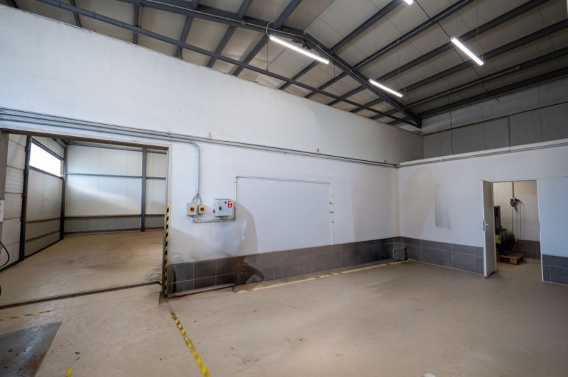 Industrielles Interieur mit weißen Wänden und Betonboden. Besondere Immobilien.