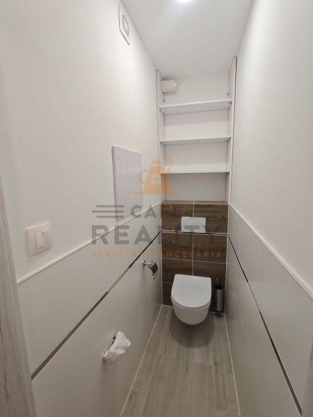 Gemütliches Badezimmer mit Holzboden in einer Einzimmerwohnung.