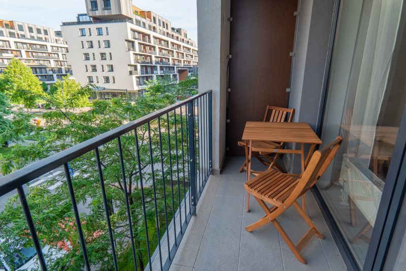 Balkon einer Einzimmerwohnung in der Zuzany-Chalupovej-Straße, Bratislava - Petržalka mit Holzmöbeln.