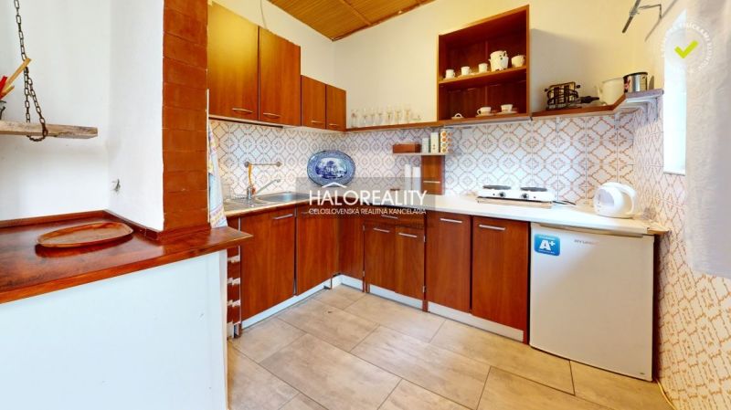 Eine Küche in einer Hütte mit Holzmöbeln und gemusterten Wandfliesen.