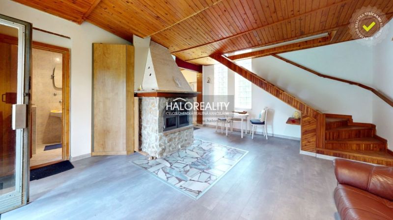 Das Innere der Hütte mit einem Holzboden, einem Kamin und einer Treppe.