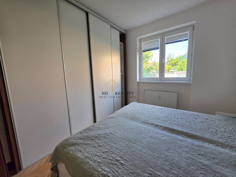Schlafzimmer mit Einbauschrank und Fenster in einer 2-Zimmer-Wohnung.
