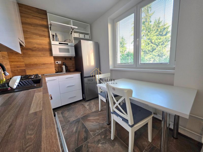 Küche in einer 2-Zimmer-Wohnung mit Holzelementen und Blick ins Grüne.