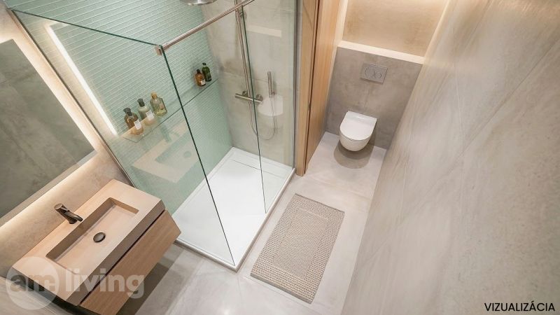Badezimmer in einer 2-Zimmer-Wohnung mit Dusche, Waschbecken, Toilette und Matte.