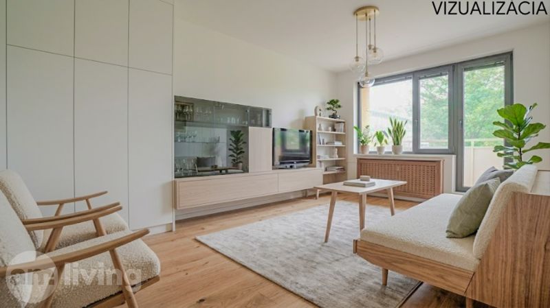 Wohnzimmer mit Holzboden, Sofa und Zimmerpflanzen in einer Zweizimmerwohnung.