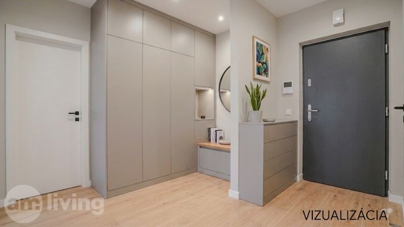 Eingangsflur in einer 2-Zimmer-Wohnung mit Holzboden, Einbauschränken und Dekorationen.