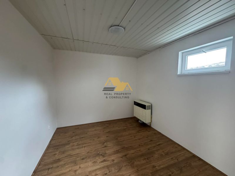 Ein Zimmer mit Holzboden und weißen Wänden in einer 2-Zimmer-Wohnung.