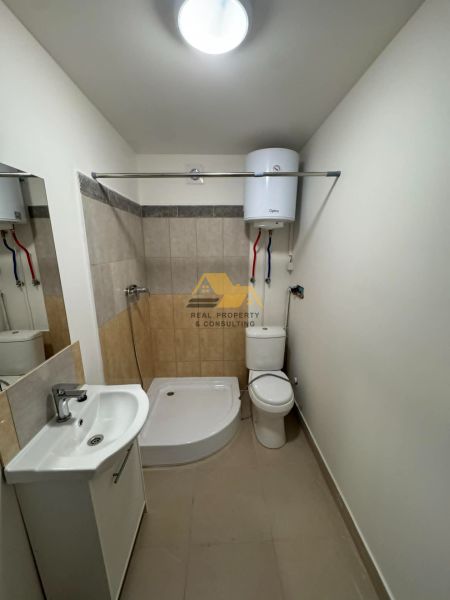 Badezimmer in einer 2-Zimmer-Wohnung mit Badewanne, Waschbecken und Toilette, helle Wandfliesen.