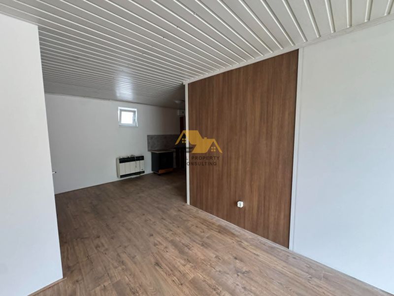 2-Zimmer-Wohnung mit Holzboden und weißen Wänden.