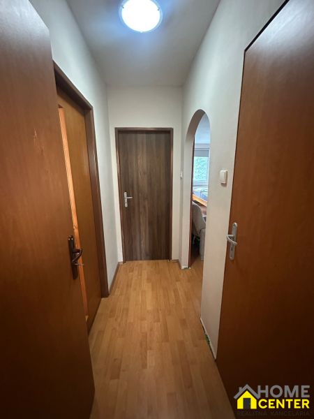 Der Flur in einer 3-Zimmer-Wohnung mit einem Boden in Holzoptik und Türen.