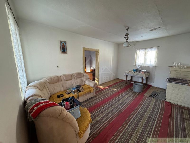 Wohnzimmer in einem Einfamilienhaus mit Kachelofen, Teppich und Sofa ohne Holzdekor.