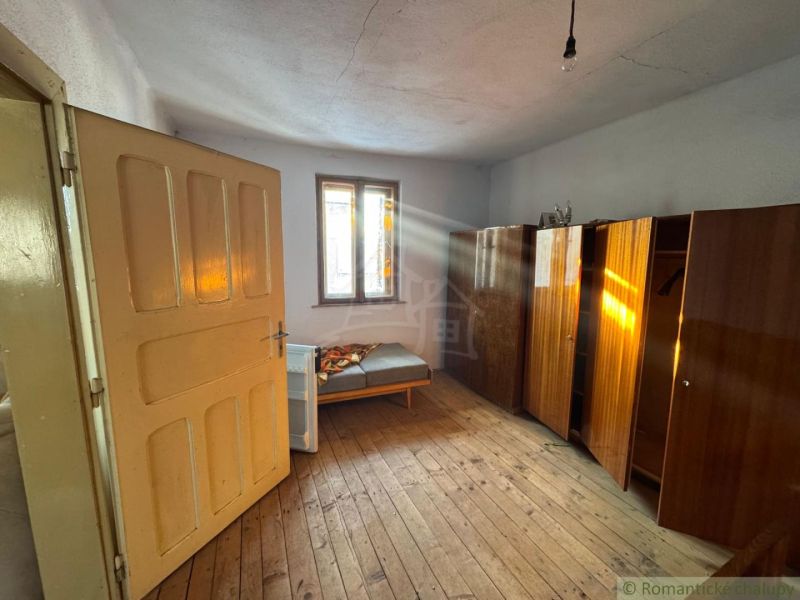 Ein Zimmer in einem Einfamilienhaus mit einem Boden in Holzoptik und einfacher Einrichtung.