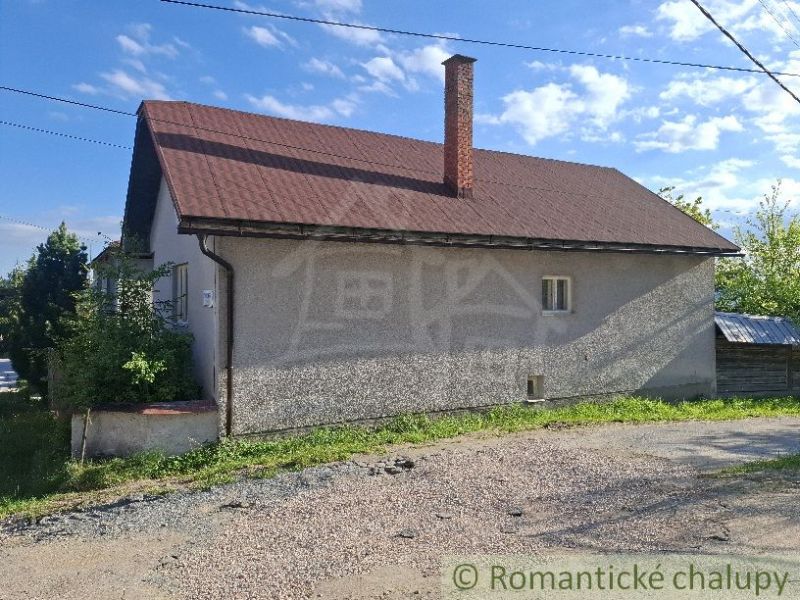 Ein Einfamilienhaus in Šumiac mit einer einfachen Fassade und einem schrägen Dach.