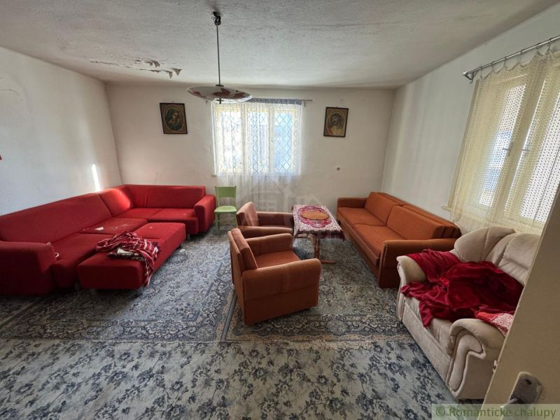 Wohnzimmer in einem Einfamilienhaus mit roten und orangenen Sofas und einem Teppich.