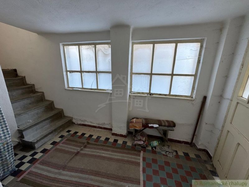 Innenraum eines Einfamilienhauses mit Treppe, Teppich und großen Fenstern.