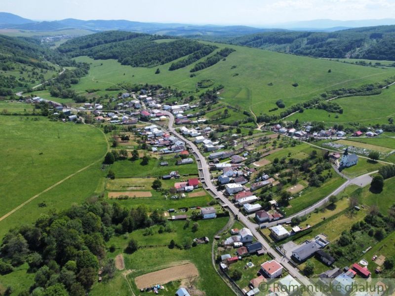Luftaufnahme des Dorfes Karná, umgeben von Hügeln und Wohngebieten.