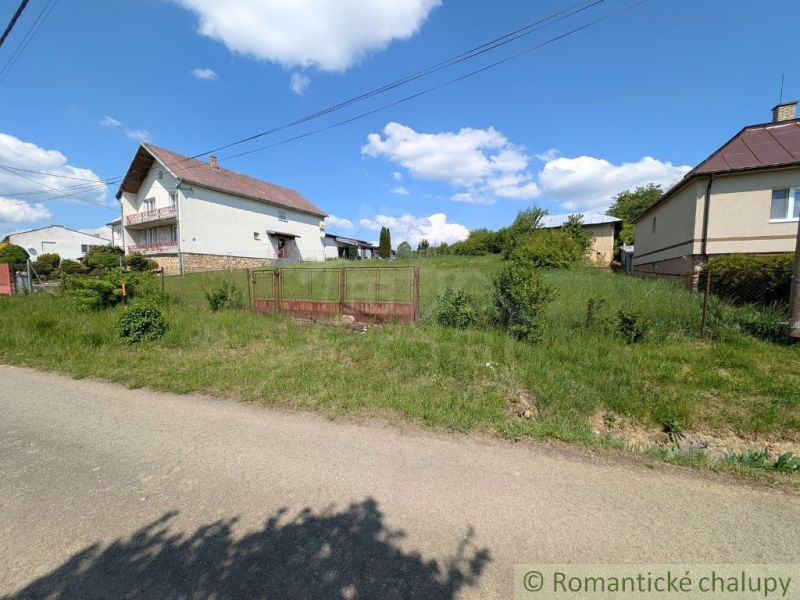 Ein von Grün umgebenes Haus in Karna, von einem Zaun umgeben, ideal für Wohnbaugrundstücke.