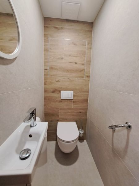 Badezimmer in einer 2-Zimmer-Wohnung mit Holzboden und hängendem WC.