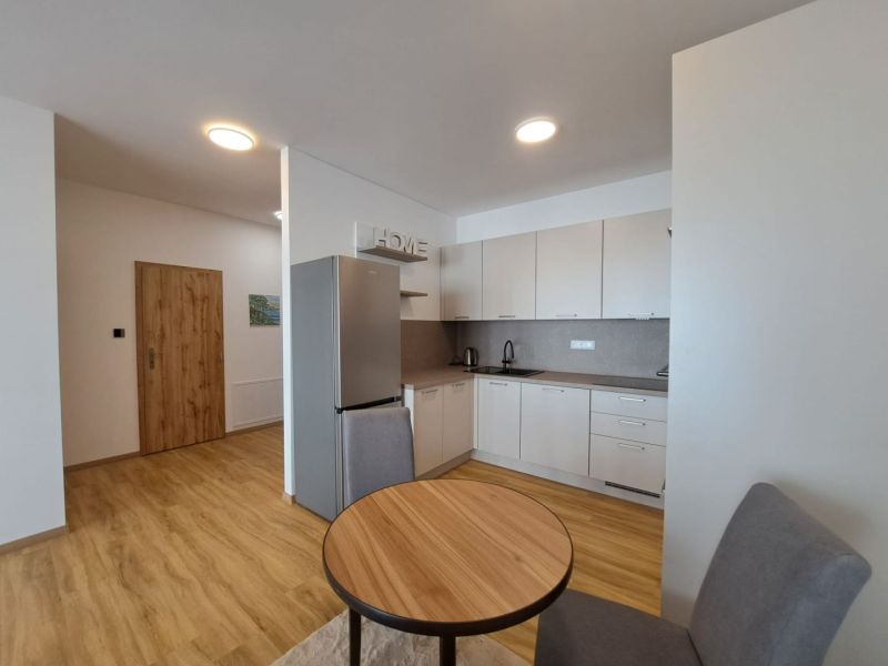 Küche in einer 2-Zimmer-Wohnung mit Holzboden und stilvollen Schränken.