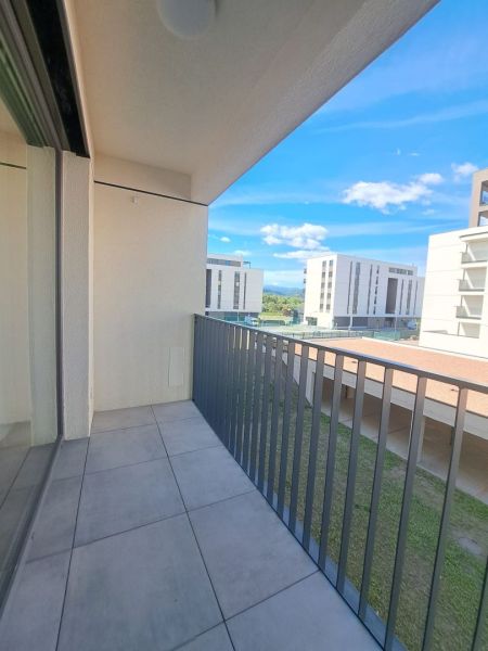 Balkon in einer 2-Zimmer-Wohnung in Poprad mit Blick auf moderne Gebäude und Grünflächen.