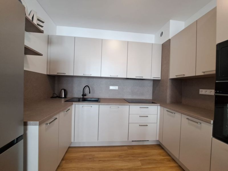 Küche in einer 2-Zimmer-Wohnung mit Holzboden und elegantem Möbel.