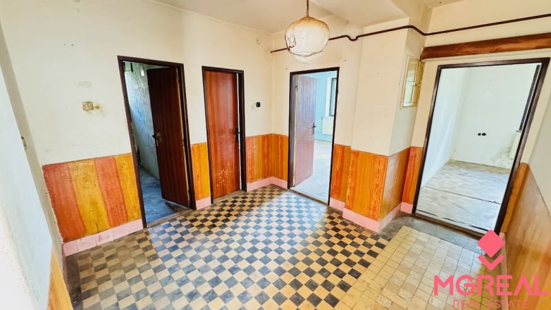 Flur im Einfamilienhaus mit Fliesen und Holzelementen an den Wänden.