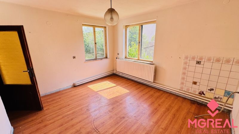 Ein geräumiges Zimmer mit Holzboden in einem Einfamilienhaus.