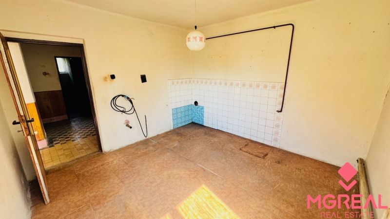 Innenraum eines Einfamilienhauses mit weißen Wänden und einem Boden in Holzoptik.