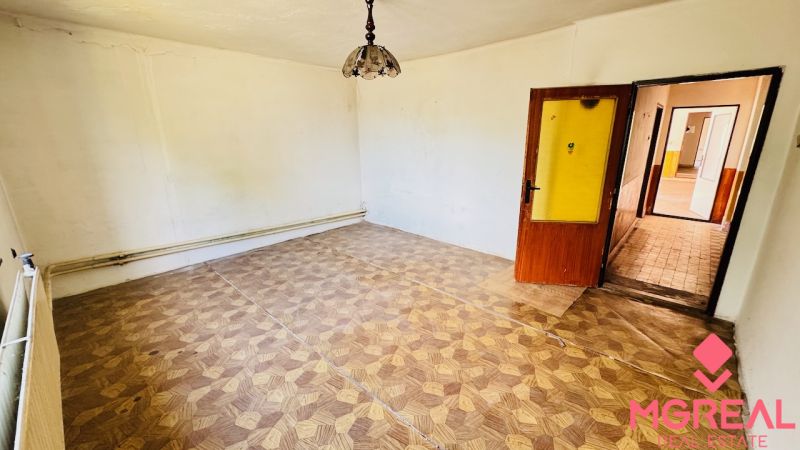 Ein Zimmer mit Holzboden und einer Lampe in einem Einfamilienhaus.
