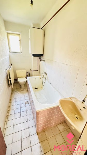 Badezimmer in einem Einfamilienhaus mit Badewanne, Waschbecken und Toilette.