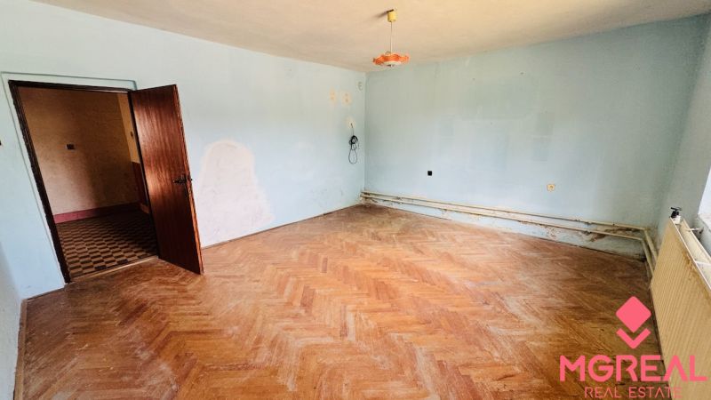 Ein Einfamilienhaus mit hellblauen Wänden und einem Boden in Holzoptik.