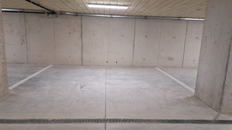 Unterirdische Garage mit Betonboden und Beleuchtung.