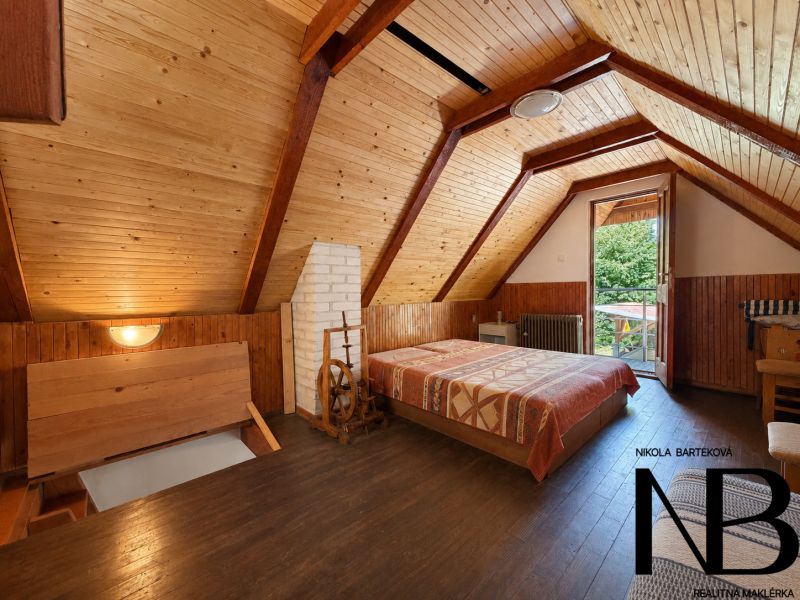 Das Innere der Hütte mit Holzverkleidung und Boden in Holzoptik, sichtbares Bett und Eingang.